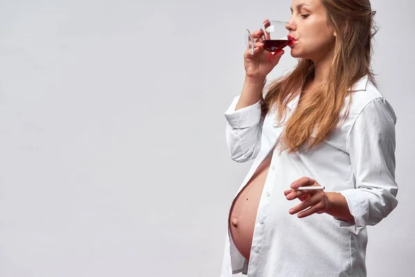 Rökning och alkohol graviditet. en kvinna på en lång graviditet dryck — Stockfoto