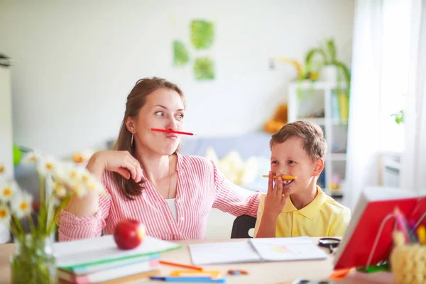 Madre ayuda a su hijo a hacer lecciones. educación en casa, clases en casa. No. — Foto de Stock