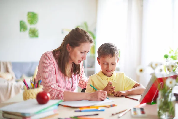 Madre aiuta il figlio a fare lezioni. scolarizzazione a casa, lezioni a casa. to o — Foto Stock