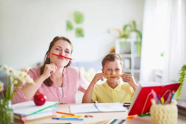 Madre ayuda a su hijo a hacer lecciones. educación en casa, clases en casa. No. — Foto de Stock