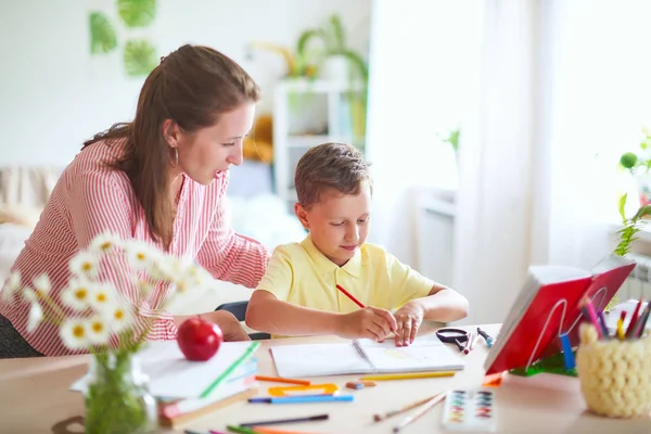 Moeder helpt zoon om lessen te doen. Thuisonderwijs, thuis lessen. Th — Stockfoto