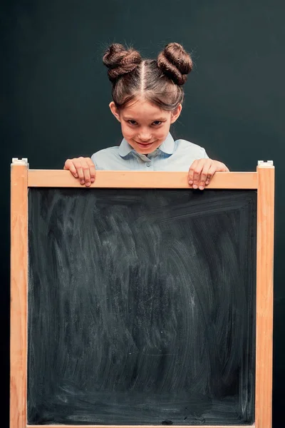Barnet visar ett tecken på godkännande stående på skolrådet. — Stockfoto