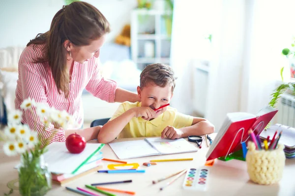 Madre aiuta il figlio a fare lezioni. scolarizzazione a casa, lezioni a casa. to o — Foto Stock