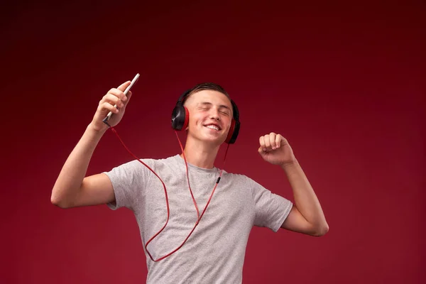 the guy is dancing with headphones. teenager listening tracks an