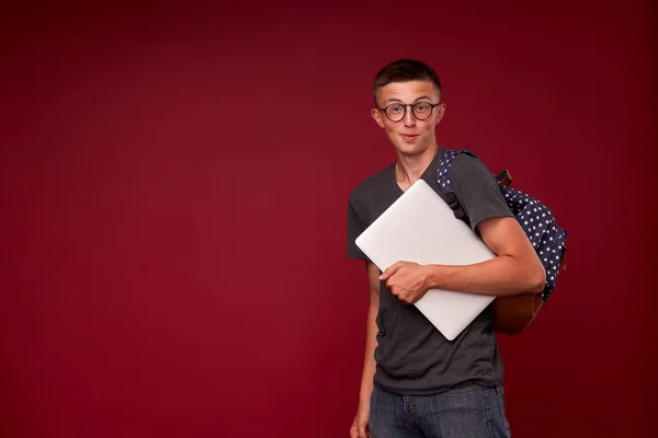 Портрет мальчика-студента с рюкзаком и ноутбуком в руке — стоковое фото