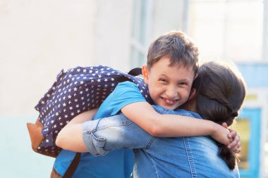 Okula dönüyoruz. Mutlu anne ve oğul kucaklamak içinde ön bu ele