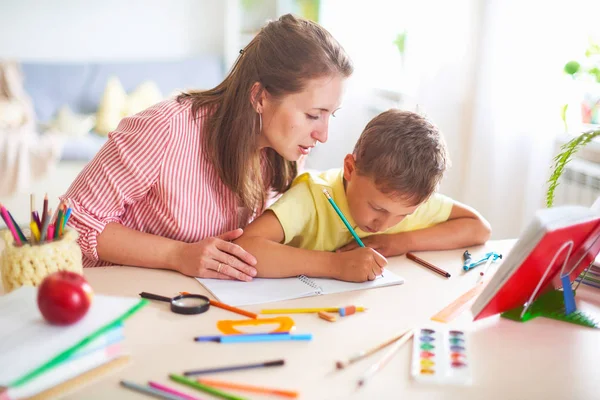 Anya segít fia csinálni órákat. otthoni oktatás, otthoni leckék. Th — Stock Fotó