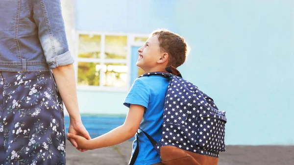 mother accompanies the child to school. mom encourages student a