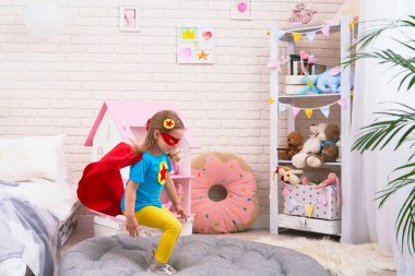 o oynarken uçmak için yataktan sevimli küçük kız atlar