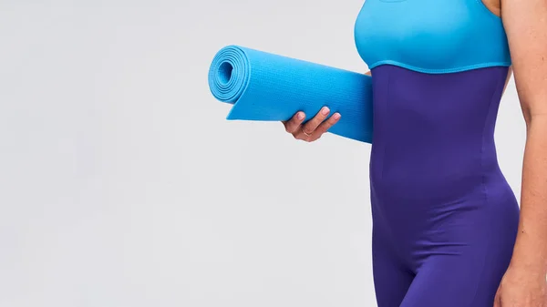 Молода спортивна жінка з килимом для гімнастики в руках . — стокове фото