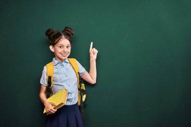 küçük kız, bir öğrenci parmağını işaret ediyor. t pozitif kız öğrenci