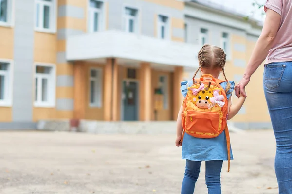 Девушка с портфелями рядом со школой . — стоковое фото