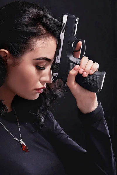 beauty portrait of a woman with a firearm in her hands