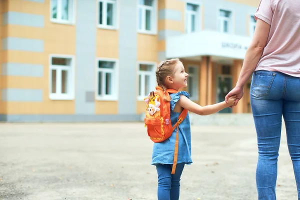 Flicka med portföljer nära skolan. — Stockfoto