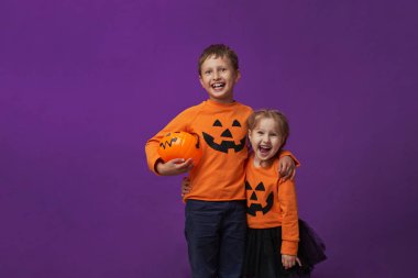 bir erkek Cadılar Bayramı kostümleri küçük bir kız kız kardeşi kucaklar.