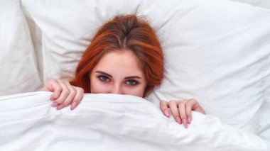 Kız neşeyle battaniyenin altından dikizliyordu..