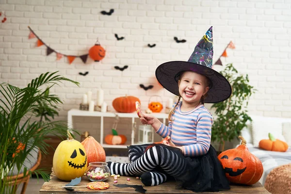 Menina em um traje de bruxa, se divertindo e rindo segurando um Lolli — Fotografia de Stock