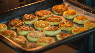 Tereyağında kızartılmış süzme peynirli peynirli kekler fırına konuyor. Ev yapımı süzme peynir ruloları fırında, çay için tatlı peynirli kekler..