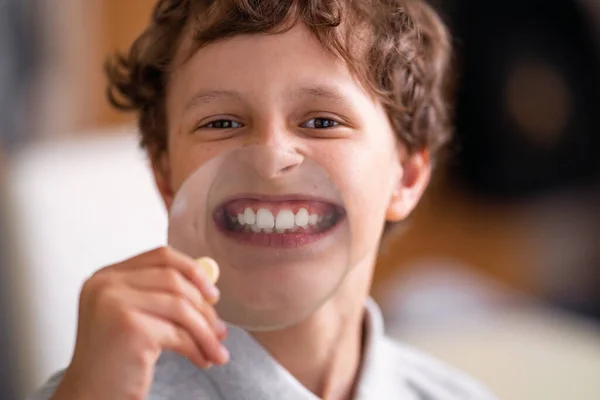 ガラスの大きな虫眼鏡をかけた明るい子供は白い歯をしています 学校に戻って 白い笑顔の健康とカール髪の学生 肯定的な感情 保育園 幼稚園歯 — ストック写真