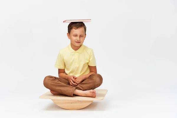 Kleine Jongen Houdt Boek Zijn Hoofd Terwijl Balanceren Speciale Simulator — Stockfoto