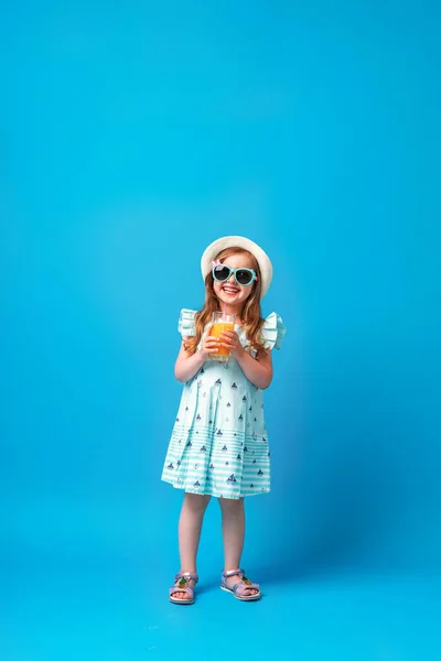 Χαριτωμένο Κοριτσάκι Ένα Φόρεμα Καπέλο Και Γυαλιά Ηλίου Θέτει Ένα — Φωτογραφία Αρχείου