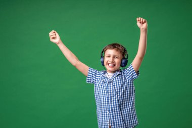 Duygularla dolu. Kulaklıkla çalan şarkının tadını çıkarıyorum. Küçük bir çocuk bir şarkıda vokal yapıyor, büyük bir müzik hayranı. Karaoke ve eğlence. Şarkıya yeşil arka planda katıldım..