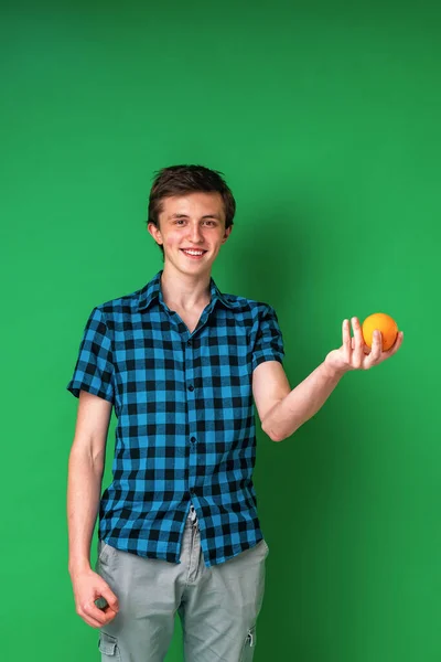 Egy Vidám Magas Fehér Tinédzser Ellenőrzött Ingben Egy Narancsot Tart — Stock Fotó