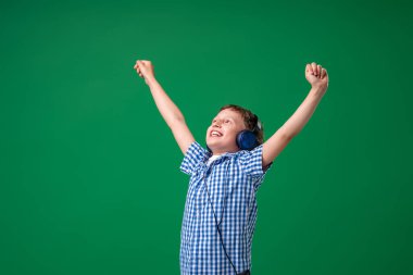 Duygularla dolu. Kulaklıkla çalan şarkının tadını çıkarıyorum. Küçük bir çocuk bir şarkıda vokal yapıyor, büyük bir müzik hayranı. Karaoke ve eğlence. Şarkıya yeşil arka planda katıldım..