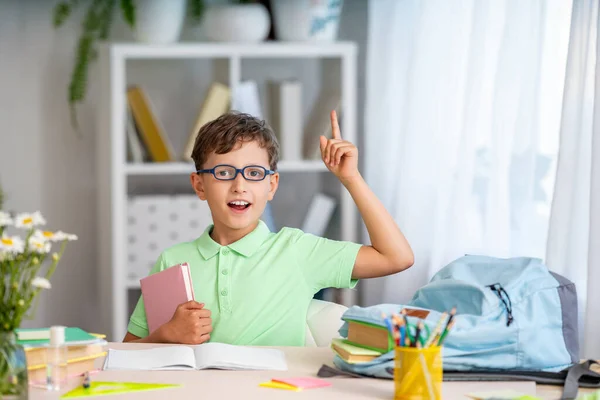 学校に戻って 幸せなスマート勤勉な少年眼鏡が部屋の机に座っています 赤ん坊は学校の準備をしている 宿題をしてる 家庭教育の概念 — ストック写真