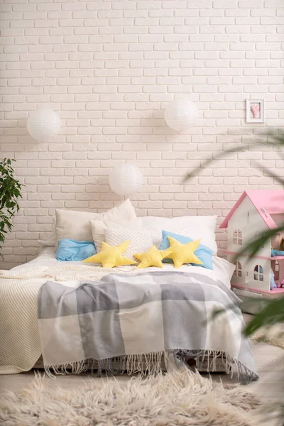 明るいリネンと居心地の良いベッド 星の形で編んだ毛布と枕 屋内植物やインテリアの多くと明るいベッドルーム 家庭の快適さとレクリエーションの概念 — ストック写真