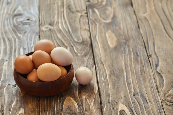 Fresh country eggs. Natural food, eco-friendly products. A group of eggs lies in a wooden plate on the surface for sale. Natural protein nutrition. Macro. copy of space. To close. Background image.