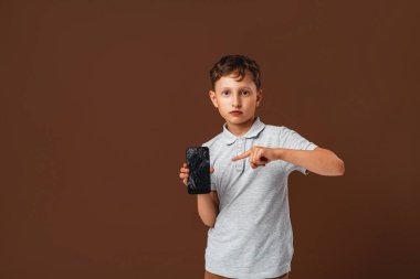 Korkmuş küçük çocuk, yanlışlıkla akıllı telefonu bozduğum için şoktayım. Bozuk cep telefonuyla hayal kırıklığına uğramış çocukların portresi. Üzgün çocuk cep telefonu ekranını kırdı. Ellerde çatlak görüntüler çocuklar.