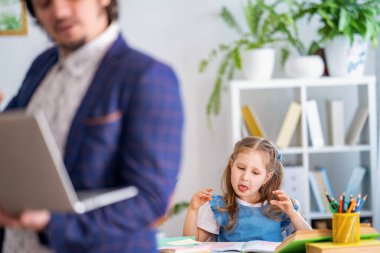 Şirin küçük kız öğretmeniyle evde ders alıyor, şakalaşıyor ve gülüyor. İlkokul öğretmeni. Anaokulu eğitimi. Babam ödevlerine yardım ediyor. Bireysel eğitim. Öğrenme ile ilgili sorunlar.