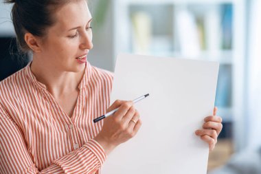 İlkokul öğretmeni konu derslerini online uzaklık öğrenmesini açıklıyor. Yüzeyde işaretle yazıyor. Tecrit döneminde eğitim gören öğrenciler. Özel ders sırasında okul çocukları için çevrimiçi dersler veriyor.