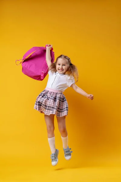 Aluna Travesso Alegre Uniforme Com Mochila Salta Sobre Fundo Amarelo — Fotografia de Stock