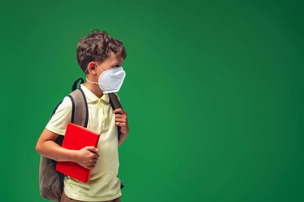 Szomorú Iskolás Fiú Hátizsákkal Védőmaszkos Könyvekkel Zöld Háttérrel Gyerek Feldúltan — Stock Fotó