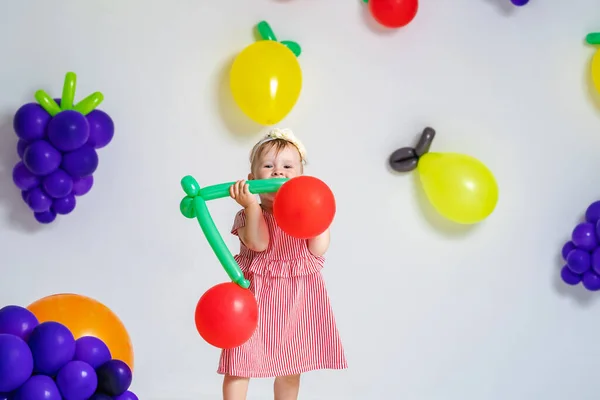 迷人的 可爱的小女孩 形似樱桃的气球在水果的背景上摆姿势 一个小孩在工作室的背景气球上摆出形状像水果的姿势 夏天的概念维生素水果复制空间 — 图库照片