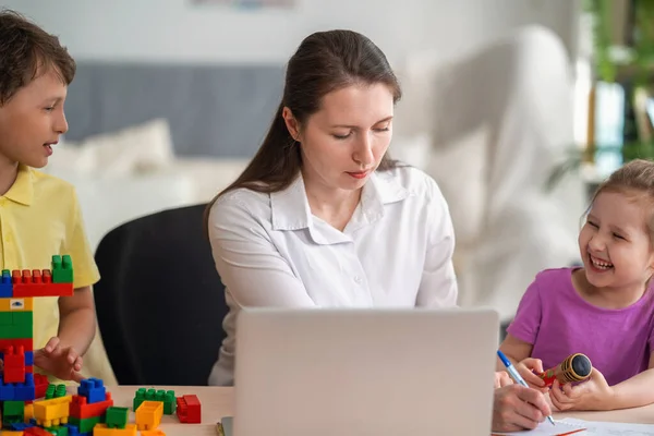 Egy Fiatal Otthon Dolgozik Egy Laptoppal Két Gyerekkel Gyerekek Kommunikálni — Stock Fotó
