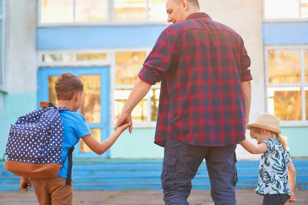 baba okula kadar çocuklara eşlik eder. Oğlu ve kızı olan bir adam arkadan çıkarıldı. Sevgi dolu bir baba okula giden çocuklarının elini tutar. Çocuk ilkokula gittiği için mutlu.