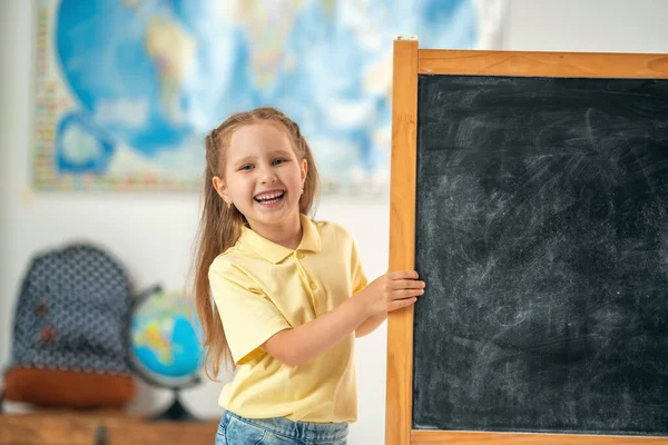 Leende Skolflicka Kikar Bakom Svart Tavla Ett Klassrum Tillbaka Till — Stockfoto