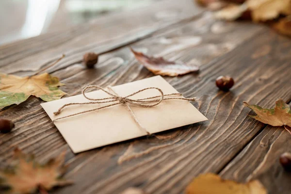 Obálka Dopisem Leží Hnědém Dřevěném Stole Suchým Jasným Podzimním Listím — Stock fotografie