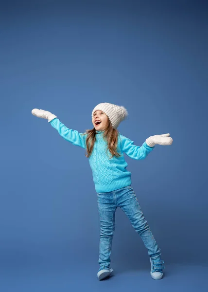 快乐的小女孩4岁 金发碧眼 头戴针织帽衫 头戴手套 笑容满面 站在紫丁香的背景上 假日周末 — 图库照片