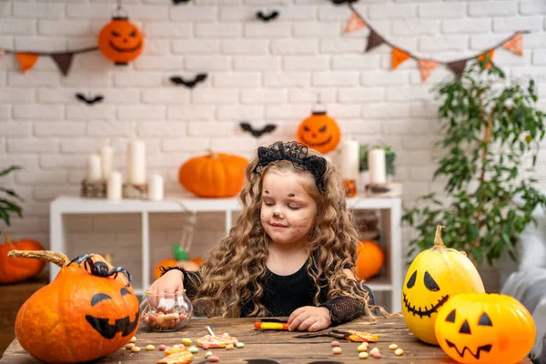 Щасливого Хелловін Маленька Дівчинка Костюмі Відьми Хелловін Сидить Столом Цукерками — стокове фото