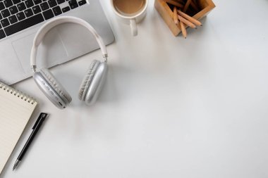 Kulaklıklar ve kitap masanın üstünde, en üstte.