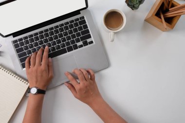 Beyaz masada dizüstü bilgisayar kullanan kadın eller, üst görünüm