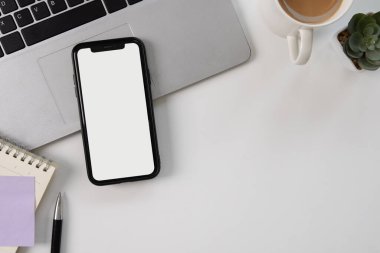 Beyaz masadaki beyaz model cep telefonu ekranı, üst görünüm