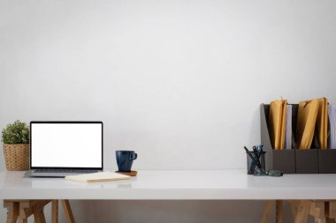 Çalışma masasının beyaz dizüstü bilgisayarı olan ön görüntüsü