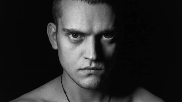 Siyah arka planda genç bir adamın portresi.