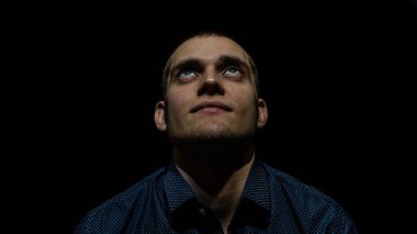 Siyah arka planda genç bir adamın portresi.
