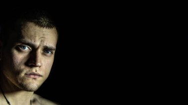 Siyah arka planda soldaki adamın yüzü.